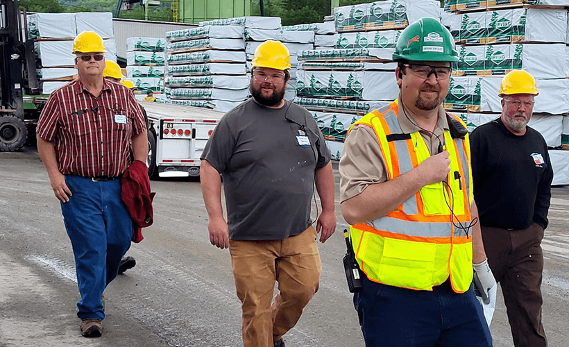 Staff outdoors near pallets of product