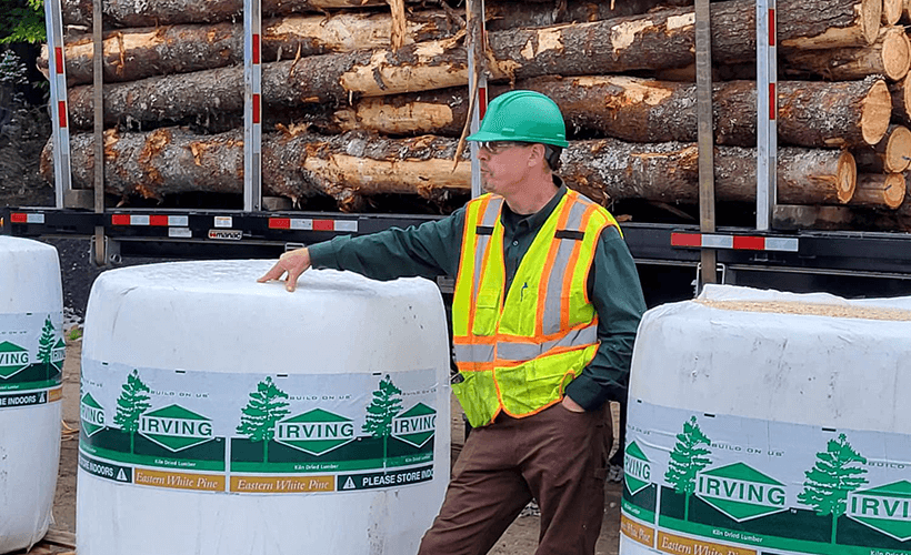 Staff member resting near product and log trucks