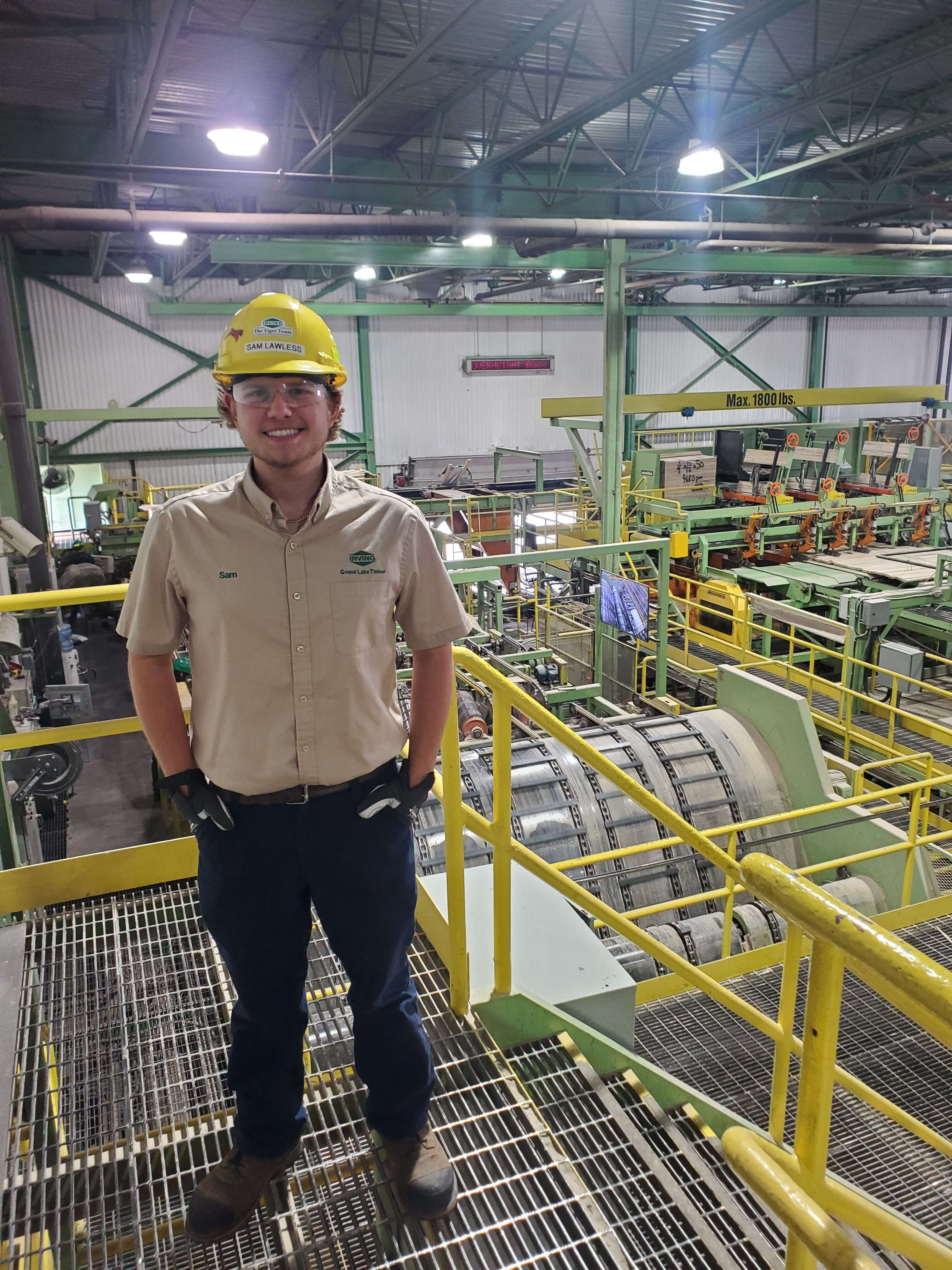 Samuel Lawless at work, standing in front of machinery
