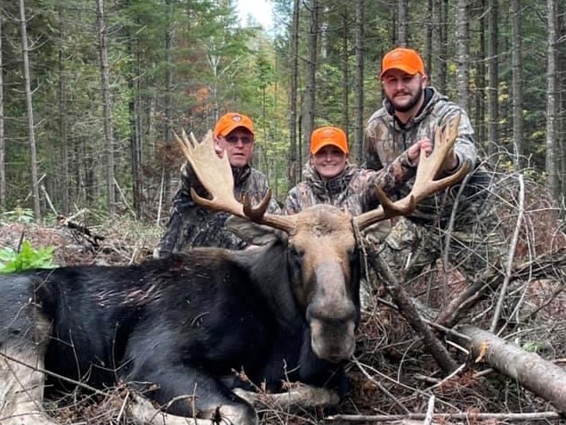 Doug Brown posing with a moose after a successful hunt